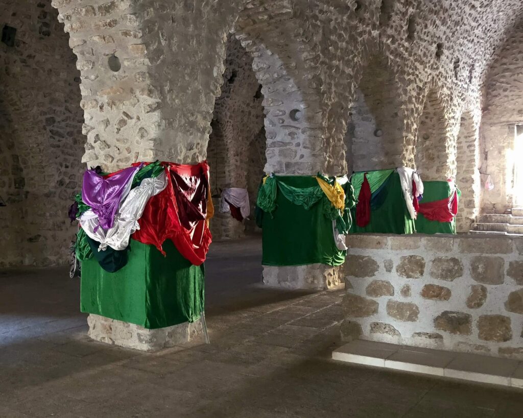 The sacred Yazidi temple in Lalish, northern Iraq, the most important religious site for the Yazidi community, featuring distinctive cone-shaped shrines and peaceful mountain surroundings, often visited on cultural tours in Iraq exploring minority heritage and spiritual traditions.