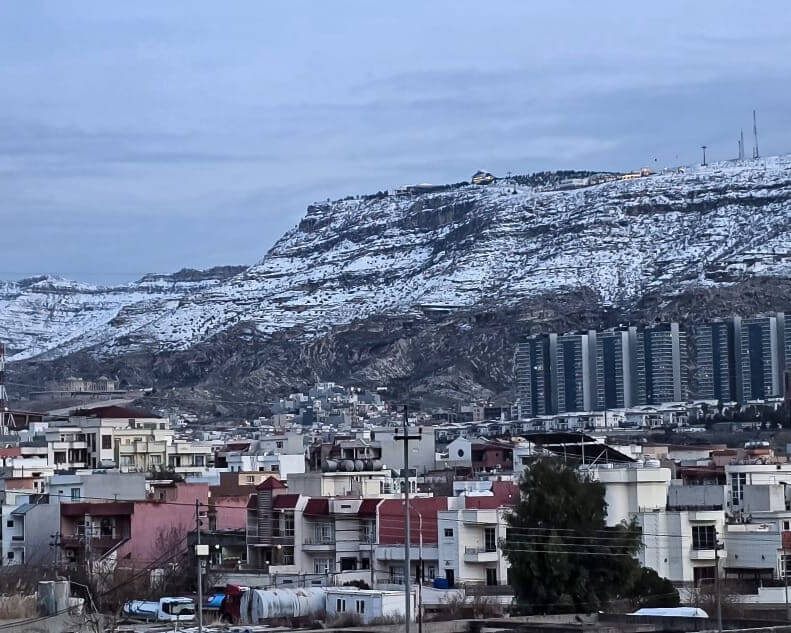 A scenic view of Duhok city surrounded by mountains in northern Iraq’s Kurdistan region, featuring urban life set against dramatic natural landscapes, often included on group tours in Iraq exploring both cultural cities and northern highland scenery.