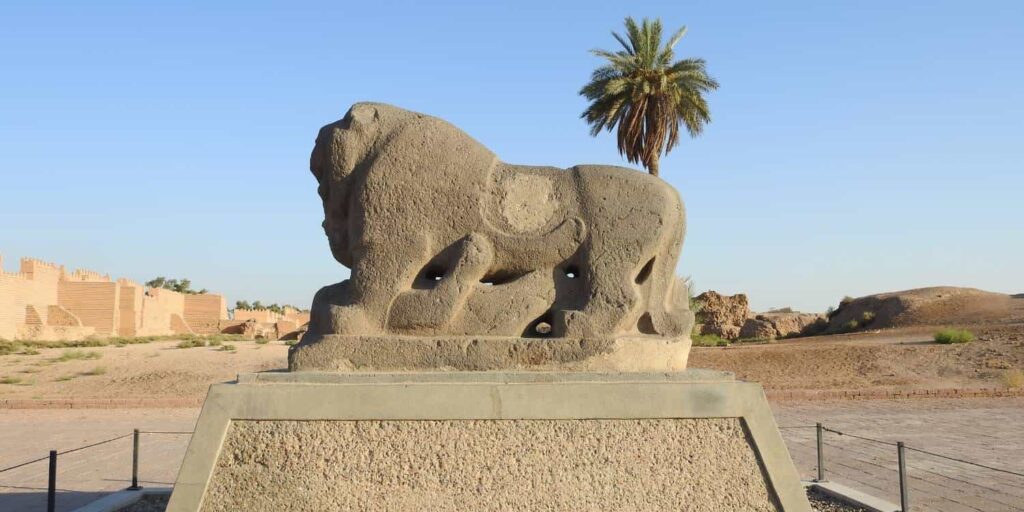 Detailed view of the ancient Lion of Babylon stone sculpture at the archaeological site of Babylon in Iraq, depicting a powerful lion standing over a human figure and representing the artistic symbolism associated with the ancient Babylonian capital.