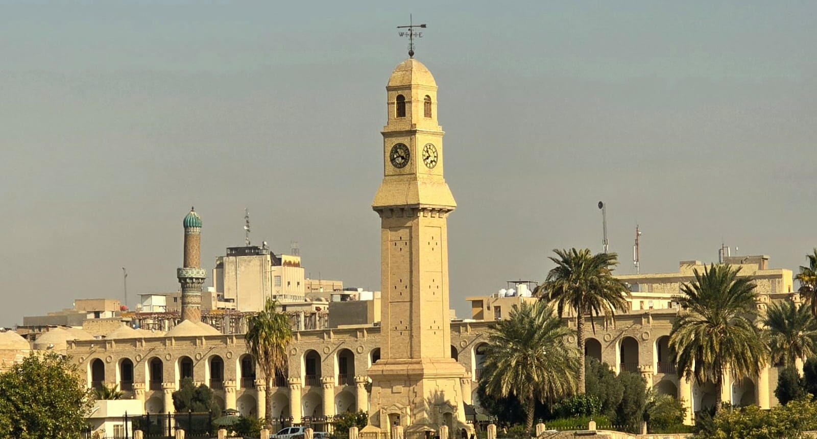 The historic Al-Qishla complex in Baghdad, Iraq, featuring its iconic Ottoman-era clock tower overlooking the Tigris River.