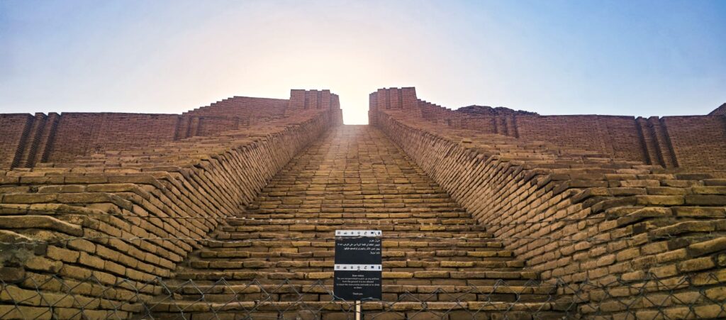 Striking view of the Ziggurat of Ur in southern Iraq, with its enormous stepped terraces and weathered brick construction standing prominently within the archaeological remains of the ancient Sumerian city of Ur.